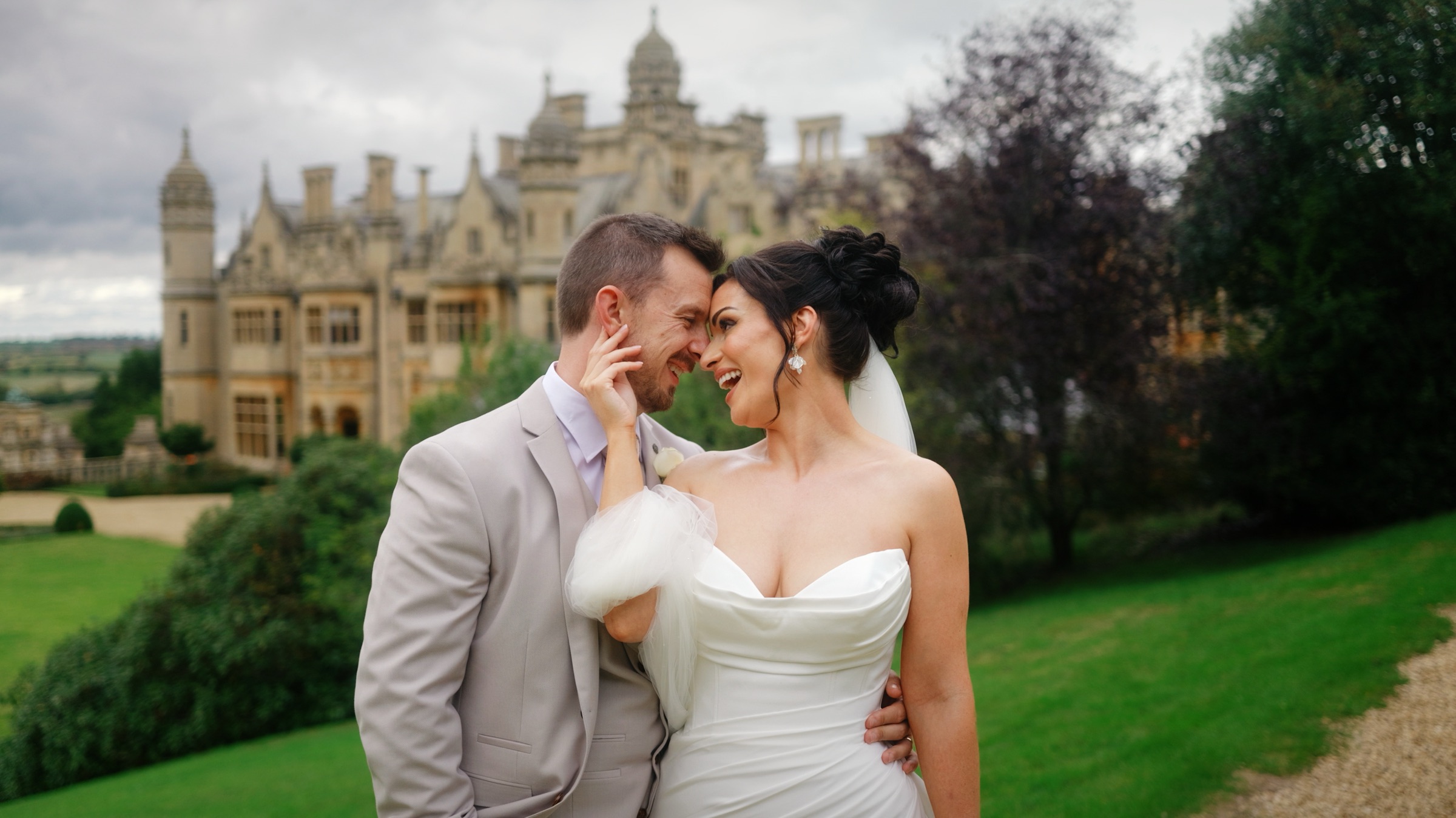 Jackie and Russell sharing a moment on the lawn in front of Harlaxton Manor