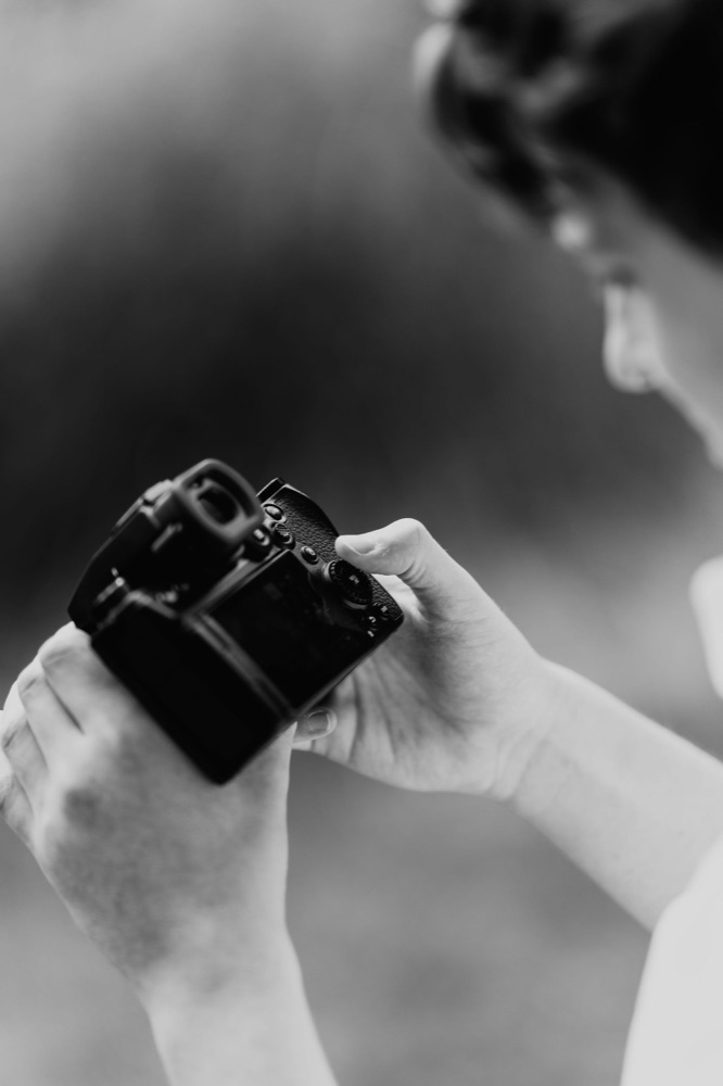 George checking shots on the back of his camera at a Lincolnshire wedding, in black and white